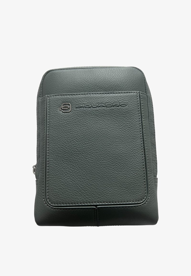 Zaino in pelle grigia con texture liscia. Caratterizzato da una tasca frontale, chiusura con cerniera e logo impresso. Design rettangolare minimalista.