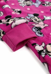 Tessuto in pile di un vivace colore rosa, con un motivo di Topolina. I polsini sono a coste con una texture liscia, che mette in evidenza colori e dettagli vivaci.