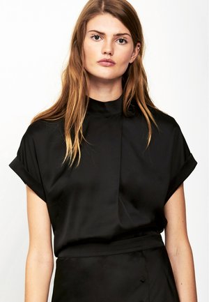 Haut en satin noir avec un col haut, des manches courtes retroussées et une texture lisse et soyeuse. Présente un design simple et épuré.