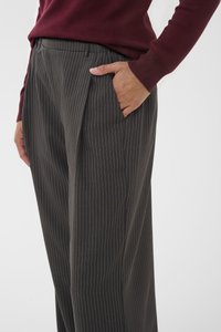 Pantalones a rayas grises hechos de una tela ligera con un corte holgado, que cuentan con un bolsillo lateral y una cintura plana para mayor comodidad.