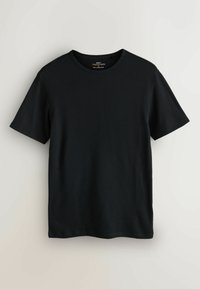 Czarny t-shirt z krótkim rękawem o prążkowanej fakturze. Okrągły dekolt i regularny krój. Metka widoczna przy dekolcie. Prosty wzór bez nadruków.