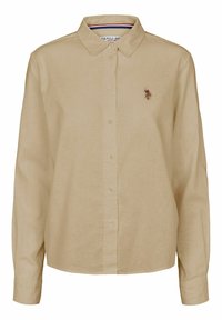 Camicia beige con bottoni realizzata in tessuto leggero, dotata di colletto e maniche lunghe. Piccolo logo ricamato sul lato sinistro del petto.