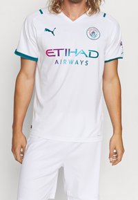 Bílý fotbalový dres s tyrkysovými akcenty, designem s výstřihem do V, obsahující logo 'ETIHAD AIRWAYS' v gradientních barvách a logo Puma na rameni.