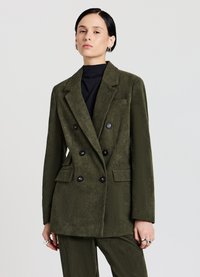 Veste en velours côtelé double boutonnage de couleur olive, avec des boutons noirs, des revers crantés et des poches avant. Texture lisse avec des côtes verticales.