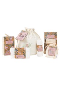 Set van milieuvriendelijke beauty-items, waaronder een katoenen pouch, badspons, haarband en herbruikbare pads, met pastelkleuren en florale verpakking.