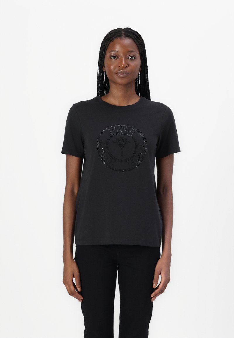 Zwarte korte mouwen T-shirt van katoen, met een glanzend rond logo ontwerp in het midden gemaakt met rhinestones. Eenvoudige, klassieke snit.