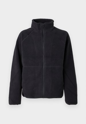 Schwarze Fleecejacke mit Reißverschluss, langen Ärmeln und hohem Kragen, aus weichem, strukturiertem Stoff, vor einem schlichten weißen Hintergrund präsentiert.