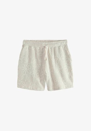 Valged kootud lühikesed püksid elastse vöökohaga, seotava paelaga, küljetaskutega ja õrna lillemustriga üle kogu riide.