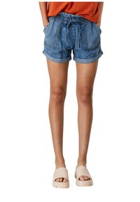 Denim shorts with an elastic waistband, front pockets, and rolled hems; light blue color and a relaxed fit paired with beige slip-on sandals.