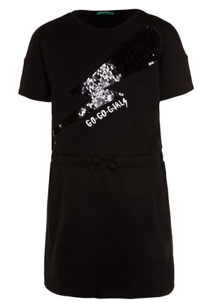 Robe noire à manches courtes avec un éclair en sequins noirs et argentés et le texte blanc « Go-Go-Girls » sur la poitrine, avec un lien à la taille.