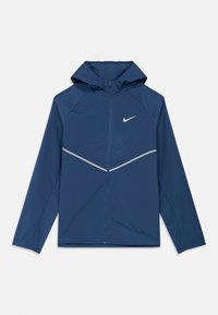 Blaue, leichte Kapuzenjacke mit durchgehendem Frontreißverschluss, reflektierendem Chevron-Detail über der Brust und kleinem Nike-Logo auf der linken Brustseite.