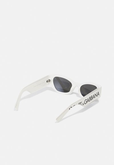 Hvite plastsolbriller med mørke linser, kantete design, tykke stenger, og merkevarenavnet "Dolce & Gabbana" trykket på siden.