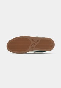 Rubber outsole with a brown and cream color scheme. Features a textured pattern and embossed logo, designed for traction and stability.