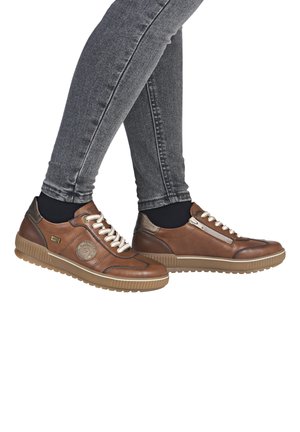Des sneakers en cuir marron présentent un bout rond, des coutures contrastées, un design à lacets et une semelle en caoutchouc texturé. Détail avec zip sur le côté inclus.