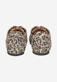 Mocassins en daim à imprimé léopard avec une semelle noire flexible, un dos arrondi et une doublure rouge contrastante visible à l'intérieur.