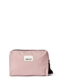 Pink nylon taske med rektangulær form, sort lynlås og et hvidt mærke, der står "DAY ET." Glat tekstur, minimalistisk design.