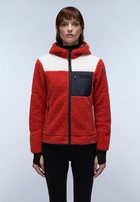 Red fleece jacket with white and navy accents, zippered chest pocket, hood, and textured fabric, fitted with black sleeves.