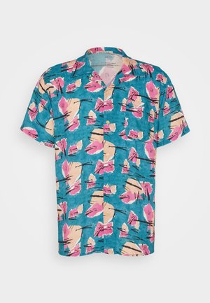 Camisa de manga corta con botones, con patrones florales abstractos en rosa, beige y negro sobre un fondo turquesa.