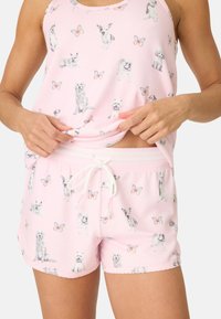 Rosa pyjamaset bestående av en tanktop och shorts, båda med ett mönster av olika hundar och fjärilar. Mjuk tyg, elastiskt midjeband, snörning.