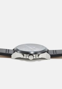 Reloj cronógrafo negro con caja de acero inoxidable y correa de cuero negra. Presenta una esfera de vidrio claro y tres botones laterales.