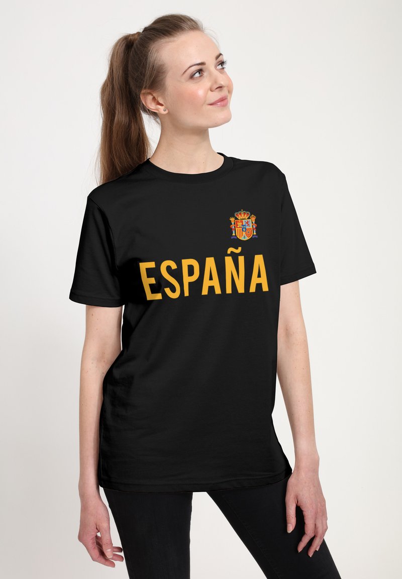 Zwart t-shirt met het woord "ESPAÑA" in vet gele letters en een klein nationaal wapen op de linkerborst.