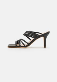 Sandale noire à talons hauts avec plusieurs brides croisées et un bout carré. Matériau en cuir lisse avec un accent texturé sur les brides.