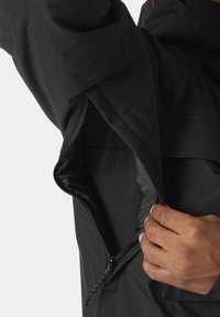 Chaqueta aislante negra con bolsillo con cremallera; tejido suave y mate; diseño duradero; cremallera ajustable a mano con un agarre firme.