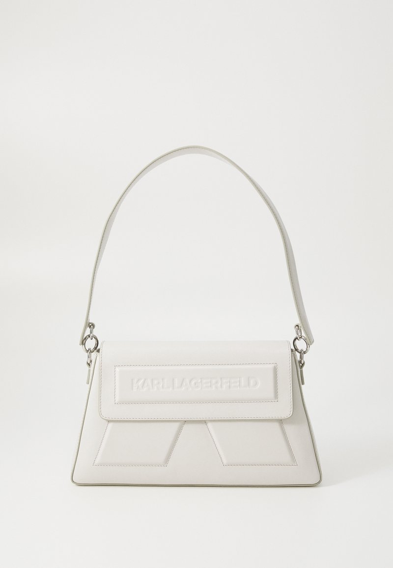 Sac à main rectangulaire blanc avec une poignée supérieure et une fermeture à rabat embossée du logo « KARL LAGERFELD » sur un fond uni.