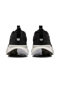 Svart träningsskor med en texturerad mesh-övre, kontrasterande vit sula och reflektiva detaljer. Har två dragremmar baktill.