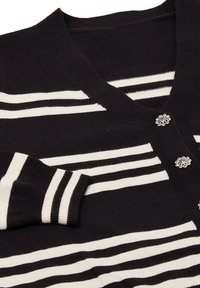 Cardigan a righe bianche e nere, con scollatura a V, polsini a coste e dettagli con bottoni decorati. Morbido tessuto lavorato a maglia.