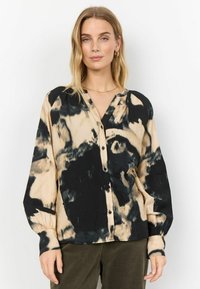 Černo-beige tričko s kravatovým vzorem, zapínání na knoflíky, dlouhé rukávy, výstřih do V, měkká textura a nařasené manžety. Má uvolněný střih.