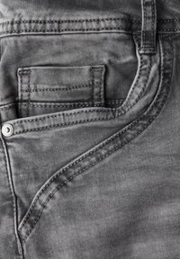 Jeans de mezclilla gris con un diseño de bolsillo en ángulo distintivo, costuras visibles y una textura suave con ligero desvanecimiento.