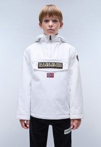 Veste blanche à col montant, dotée d'une fermeture éclair à l'avant, d'un écusson noir et d'un emblème du drapeau norvégien sur la poitrine. Un pantalon noir complète le look.