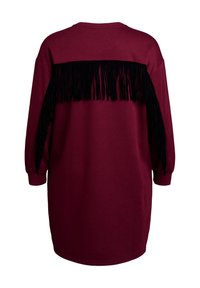 Abito felpa oversize color bordeaux con maniche lunghe, caratterizzato da un accento di frange nere sulla schiena. Tessuto morbido, silhouette rilassata.