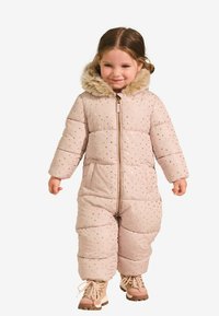 Pufasta, svijetloružičasta skijaška odjeća s uzorcima zlatnih zvjezdica i kapuljačom od umjetnog krzna. Ima prednji patentni zatvarač i široke nogavice.