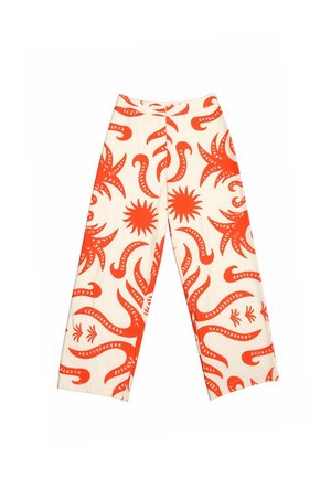 Pantalon blanc à jambes larges avec des motifs abstraits audacieux orange représentant un soleil et des tentacules, fermeture éclair à l'avant, sans poches visibles.