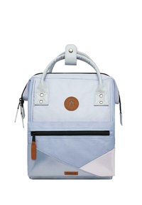 Light blue backpack with a textured surface, featuring a front zip pocket, decorative brown logo patch, and white geometric accents.