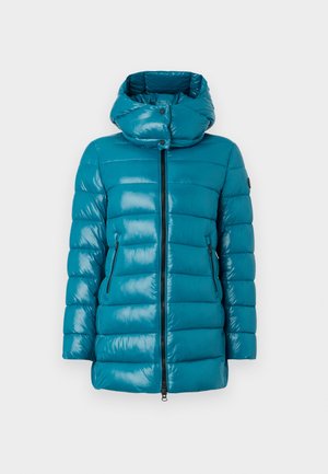Veste matelassée en teal avec col haut, zip avant et poches latérales zippées, présentée sur un fond neutre.