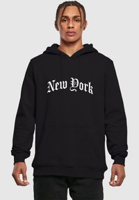 Fekete kapucnis pulóver, elülső kenguruzsebbel és díszes, vastag betűtípussal írt fehér "New York" felirattal. Puha anyagból készült, bordázott mandzsettákkal.