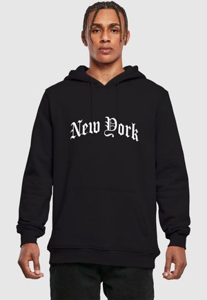 Svart hettegenser med en frontlomme i kenguru-stil og hvit "New York" tekst i en fet, utsmykket skrifttype. Laget av mykt stoff med ribbestrikkede mansjetter.