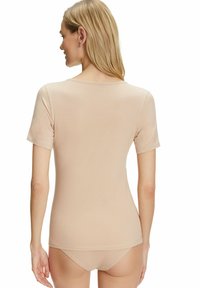 Lichtbeige top met korte mouwen, gemaakt van zachte stof, met een ronde halslijn en een naadloos ontwerp, gecombineerd met bijpassende slips.