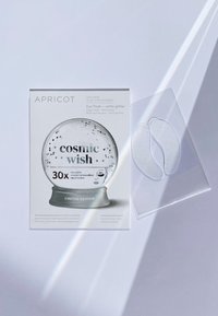 Hyaluronowe płatki pod oczy w przezroczystym opakowaniu, z designem przypominającym kulę śnieżną, z białym brokatem i srebrnymi akcentami, oznaczone "kosmicznym życzeniem."