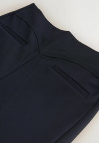 Tmavě modré kalhoty vyrobené z hladké tkaniny, s upraveným pasem, dvěma zadními kapsami a elegantním, štíhlým designem.