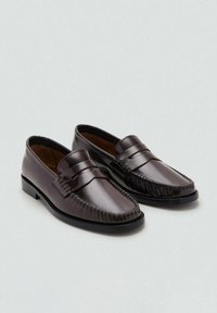 Ein Paar dunkelbraune Leder-Pennyloafer mit schwarzen Sohlen, Mokassin-Nähten und Slip-On-Design auf einem hellgrauen Hintergrund.