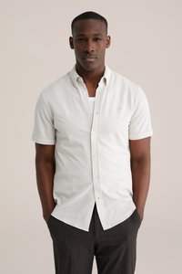 Korte mouwen, overhemd met knopen in licht beige katoen, met een ontspannen pasvorm, subtiel logo en omgeslagen manchetten. Gecombineerd met donkergrijze broek.