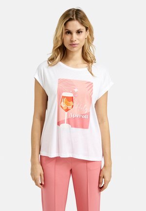 Weißes T-Shirt mit kurzen Ärmeln, das ein Grafikdesign eines Cocktailglases zeigt, mit dem Text "Holy Aperoli" und rosa Palmenblättern auf einem rosa Hintergrund.