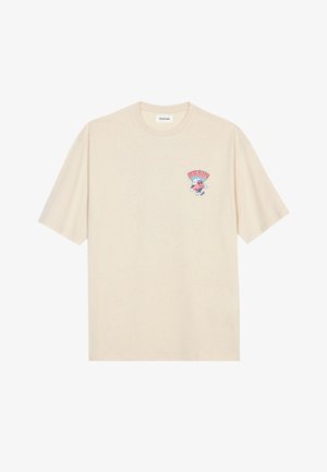 Ανοιχτό καφέ βαμβακερό T-shirt με στρογγυλή λαιμόκοψη και κοντά μανίκια. Διαθέτει πολύχρωμο καρτούν γραφικό με το κείμενο "BRAIN" στο στήθος.