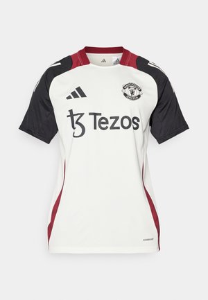 Hvid Manchester United-trøje med sorte ærmer, røde detaljer og en rund krave. Har Tezos-logoet og et fugtabsorberende design.