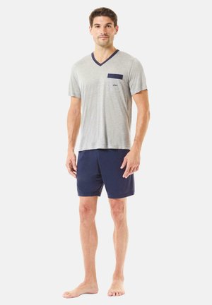 Camiseta de cuello en V de manga corta gris con bolsillo azul marino; combinada con pantalones cortos azul marino. Tejido suave, corte relajado, diseño minimalista.