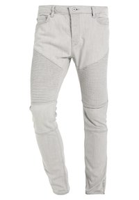 Harmaat deniminahkaiset kapealahkeiset farkut, joissa on resoroidut paneelit reisissä, vetoketjusomisteet lahkeensuuissa ja perinteinen viiden taskun malli. Sileä pinta.